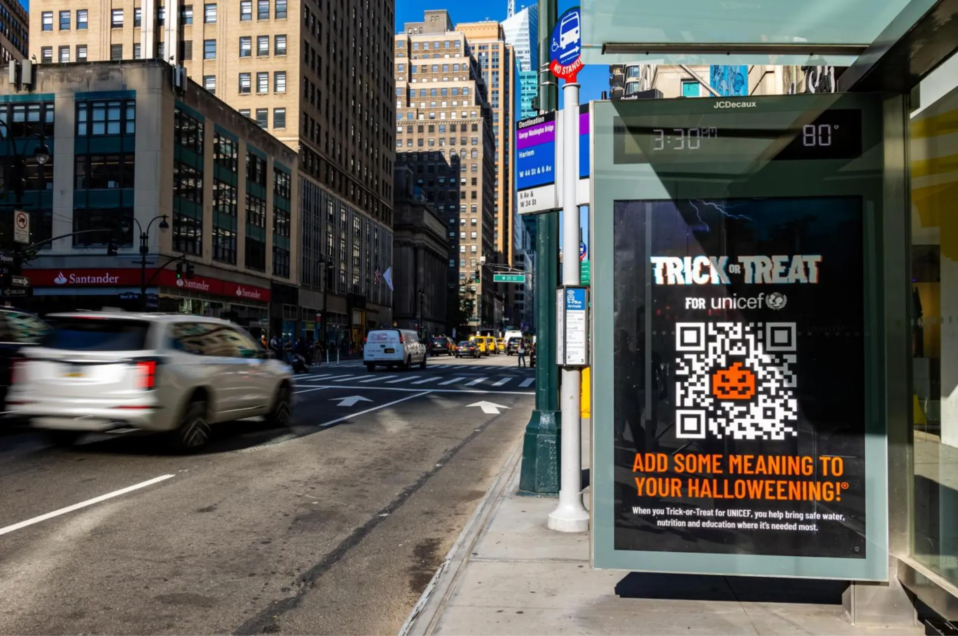 Trick or Treat for UNICEF campaign with a pumpkin QR code on a JCDecaux bus shelter screen in New York