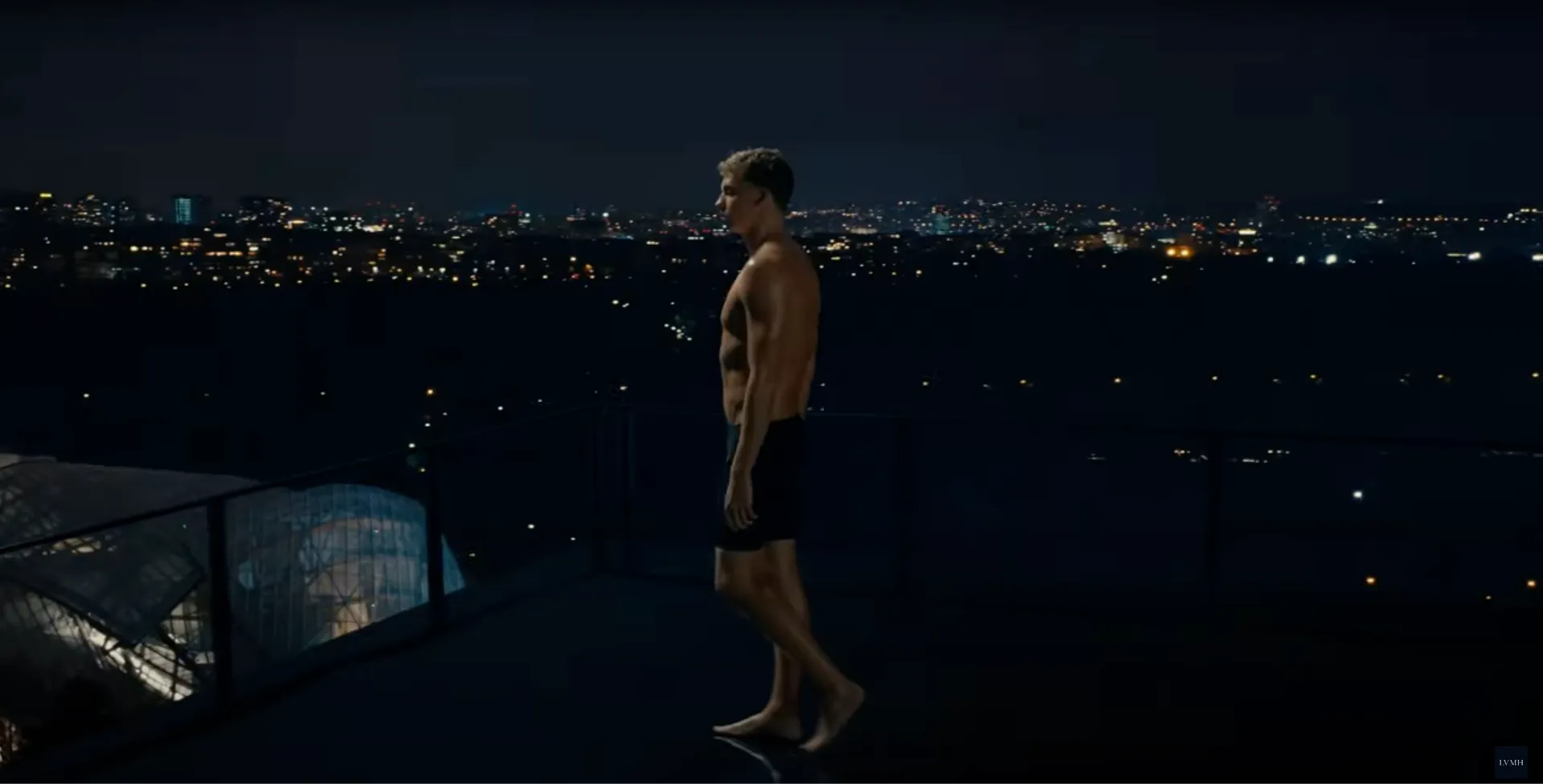 Still from LVMH's "Paris, Here We Come!" film: a swimmer stands on a Paris rooftop at night above the city lights