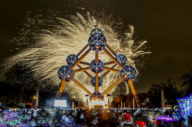 New Year fireworks bursting behind the Atomium in Brussels, crowd in the foreground