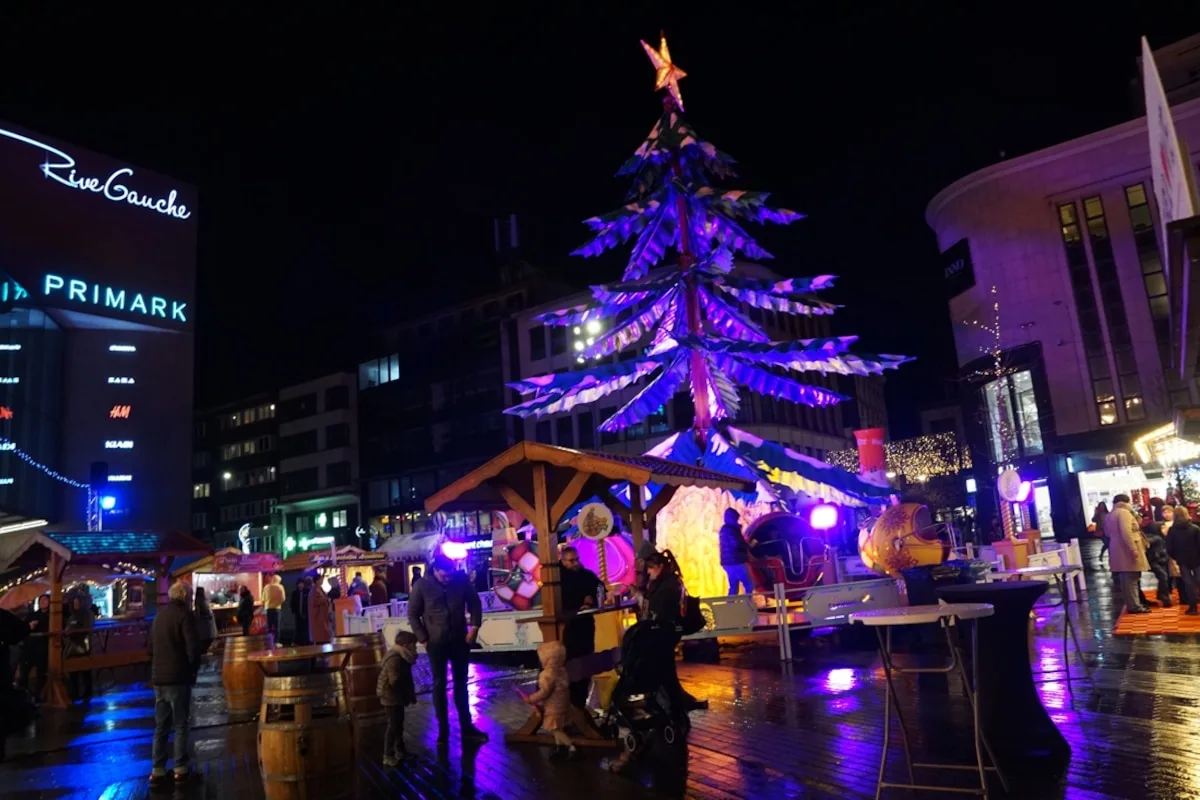 Christmas market in Charleroi at night, chalets and an illuminated tree in front of the Rive Gauche shopping centre