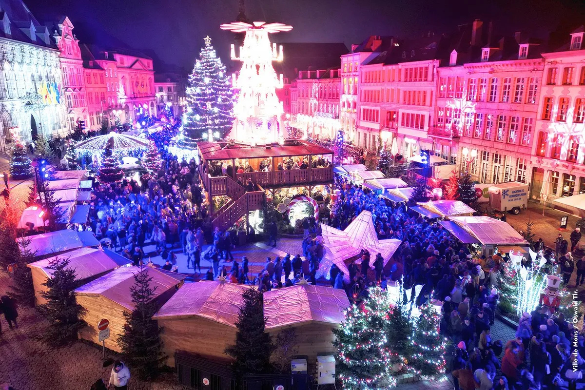 Cœur en Neige Christmas market on the Grand-Place in Mons at night, chalets, crowd and illuminated tree