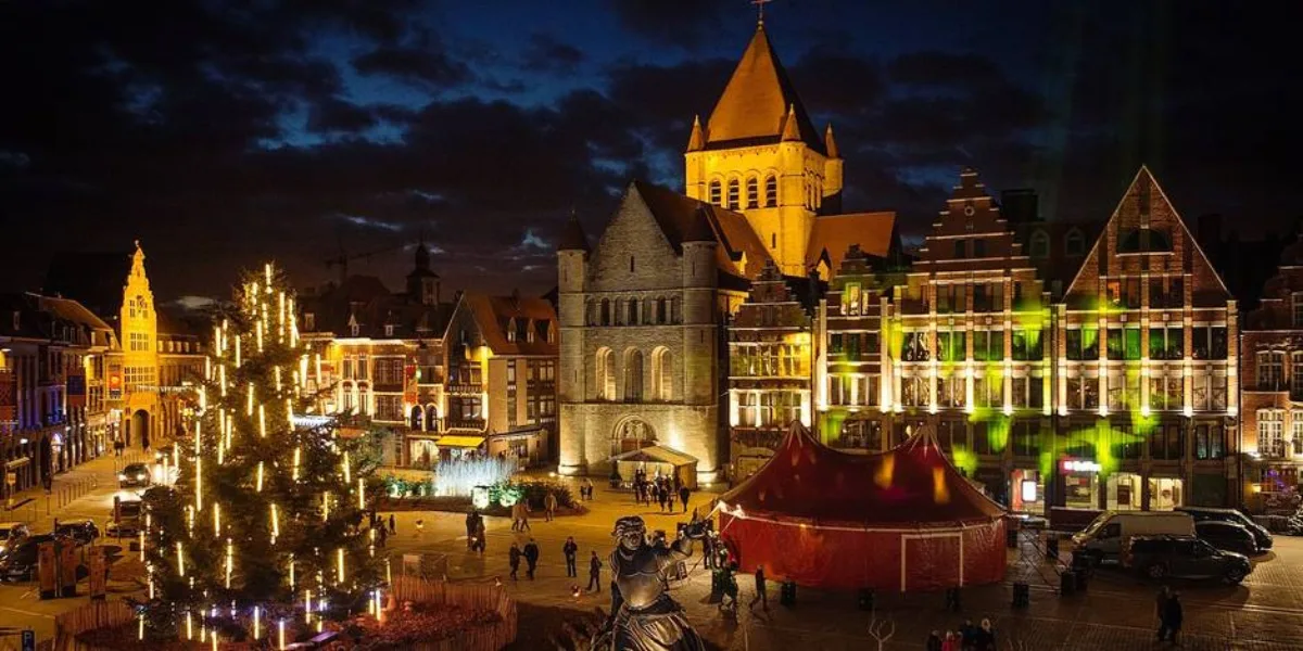 Grand-Place of Tournai at Christmas, lit tree, cathedral tower and the red market tent at night